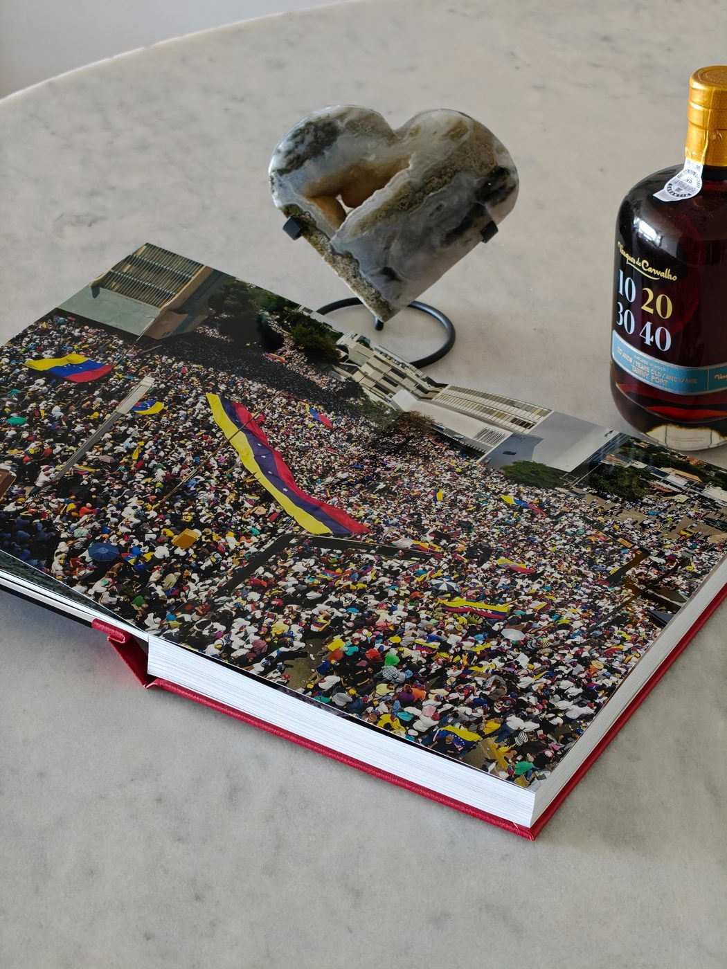 Open NiNE photobook showing a crowd scene beside a mineral sculpture